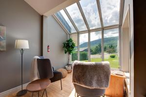 a room with a window and two chairs and a table at L'Érablière 75 - 3 chambres - 7 personnes in Saint-Férréol-les-Neiges