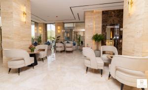 a restaurant with white chairs and tables in a room at Grand day in Al Hofuf