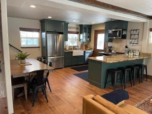 a kitchen with green cabinets and a table and chairs at The Little Dipper Cabin in Shaver Lake
