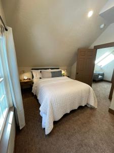 a bedroom with a large white bed in a attic at The Little Dipper Cabin in Shaver Lake