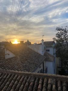 a sunset over roofs of buildings in a city at Ático - La puerta de la Alhambra in Granada