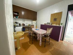 a kitchen with a table and chairs in a kitchen at Açaizeiro Hostel in Belém