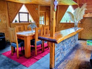 a dining room with a wooden table and chairs at Domo familiar in Chillán