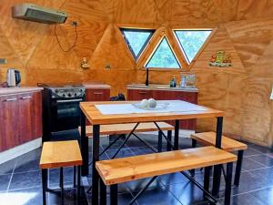 a kitchen with a table and a stove and some windows at Domo familiar in Chillán +15 photos