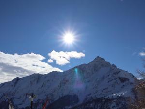 a snow covered mountain with the sun in the sky at Ski- und Berghaus Obergmeind in Tschappina +22 photos