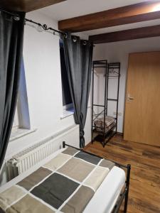 a bedroom with a bed with black curtains and a window at Alex Meißner App 2 in Großalmerode