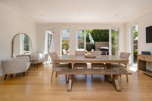 a living room with a wooden table and chairs at Evergreen by the Bay in Sandringham