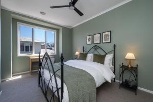 a bedroom with a bed and a window at Evergreen by the Bay in Sandringham