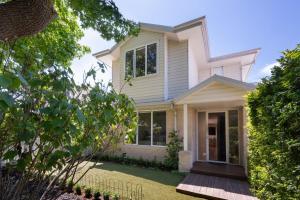 a house with a porch and a lawn at Evergreen by the Bay in Sandringham