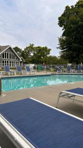 a swimming pool with blue chairs and a table at Waterbury Inn in Ephraim