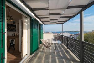 a balcony with a chair and a view of the water at Adria in Vodice
