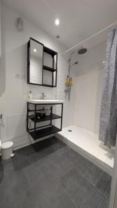 a bathroom with a sink and a tub and a toilet at Le refuge bellifontain in Fontainebleau +1 photo