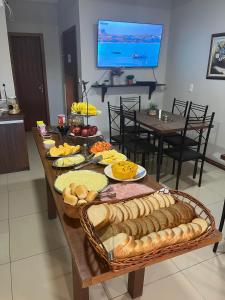a table with a bunch of different types of bread at Hotel Zona Sul in São Gabriel