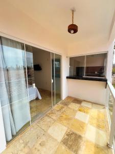 a room with glass doors and a tiled floor at Pousada Vila Didi - Flats com Cozinha Completa in Barra Grande +6 photos