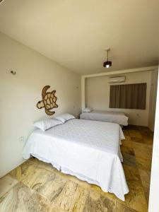 a bedroom with two beds with white sheets at Pousada Vila Didi - Flats com Cozinha Completa in Barra Grande