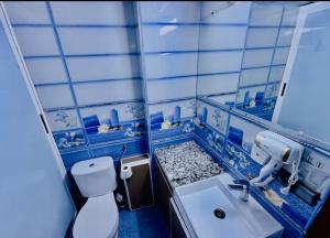 a blue and white bathroom with a toilet and a sink at Fes Apartment 2 in Fez