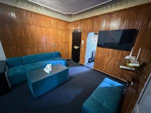 a living room with a blue couch and a tv at Fes Apartment 2 in Fez