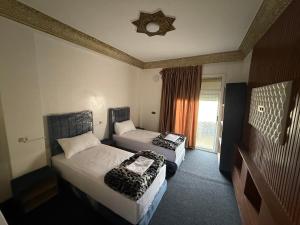 a hotel room with two beds and a window at Fes Apartment 2 in Fez