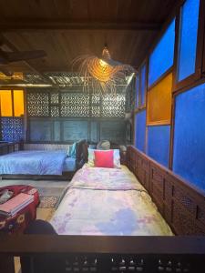 a room with two beds and a bed in it at Maison Nassimah in Giza
