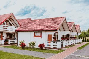 a row of white houses with red roofs at Domki Heaven Ustronie Morskie in Ustronie Morskie