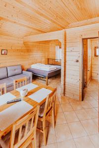 a log cabin with a table and a couch at Domki Heaven Ustronie Morskie in Ustronie Morskie