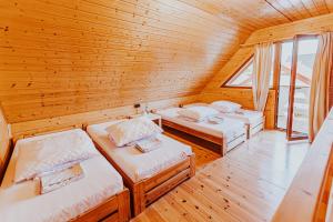 a room with three beds in a wooden cabin at Domki Heaven Ustronie Morskie in Ustronie Morskie