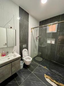 a bathroom with a toilet and a sink and a shower at Aqua Azuri apartment in Mombasa +25 photos