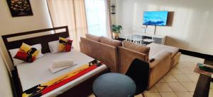 a living room with a bed and a couch at Shanzu Studio Stamford Apartment in Mombasa