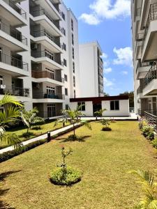 a park in front of a large building at Aqua Azuri apartment in Mombasa