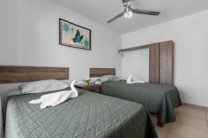 a hotel room with two beds with swans on them at Modern Pool Side, 3 Bdrm House with parking in Puerto Vallarta +21 photos