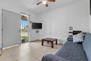a living room with a blue couch and a tv at Modern Pool Side, 3 Bdrm House with parking in Puerto Vallarta