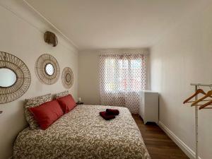 a bedroom with a bed with red pillows and a window at Pause détente proche du Zénith & Atlantis in Saint-Herblain