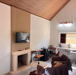 a living room with a fireplace and a tv at Chalé Bella Vista 03 in Água Boa