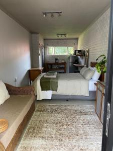a bedroom with two beds and a couch at The Cozy Acre Unit 2 in Potchefstroom