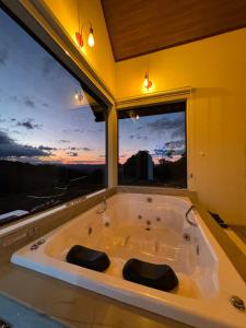 a bath tub in a room with a large window at Chalé Bella Vista 03 in Água Boa +14 photos