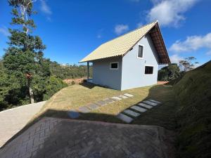 a small white house on top of a hill at Chalé Bella Vista 03 in Água Boa