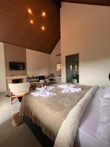 a bedroom with a large bed with towels on it at Chalé Bella Vista 03 in Água Boa