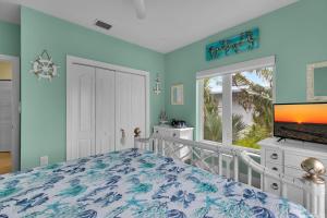 a bedroom with a bed and a tv and a window at Casa Mar in Islamorada +45 photos