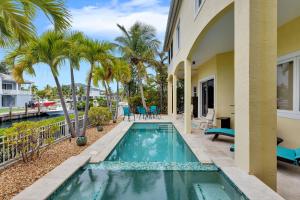 a swimming pool in the backyard of a house with palm trees at Casa Mar in Islamorada