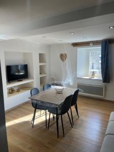 a living room with a dining room table and chairs at Le Logis des Cerfs in Les Angles