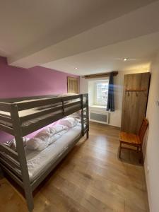a bedroom with a bunk bed and a chair at Le Logis des Cerfs in Les Angles
