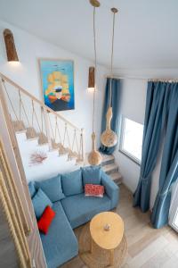 a living room with a blue couch and stairs at Libera1 in Stara Baška +34 photos