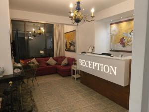 a living room with a red couch and a reception desk at Xenonas ΚITHΑIRON in Vília