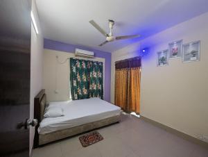 ein Schlafzimmer mit Bett und Deckenventilator in der Unterkunft Cox Flat Booking in Cox's Bazar