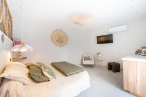 a bedroom with white walls and a bed with pillows at L'Escale - Une parenthèse en duo in Châteauneuf-du-Pape