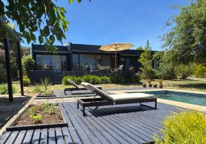 a patio with a bench and an umbrella next to a pool at Casa Campo La Tranquilidad in El Convento