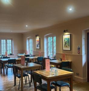 a restaurant with wooden tables and chairs and windows at The Mooring Post in Gloucester