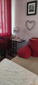 a bedroom with a bed and a table with a heart on the wall at Kerrostalomajoitus in Riihimäki