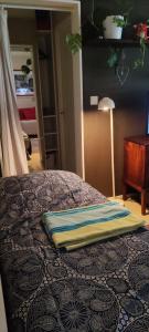 a bed with a blue and yellow pillow on it at Kerrostalomajoitus in Riihimäki