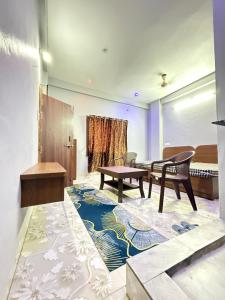 a room with a table and chairs on a rug at Omshree hotel in Ujjain